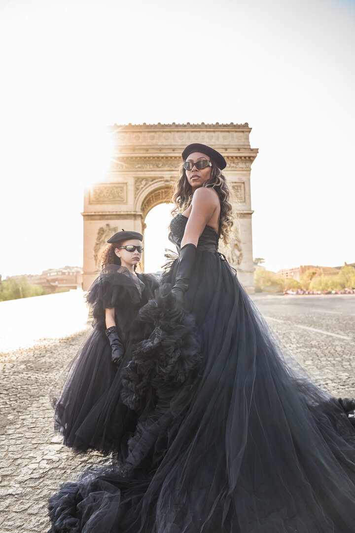 Parisian mommy and me shoot at sunrise with black outfits, berets and Arc de Triomphe view