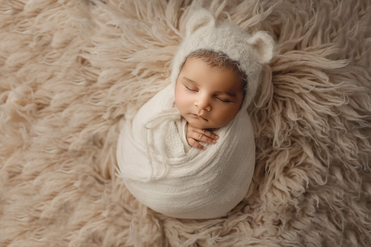 newborn baby wrapped in white wearing teddy bear bonnet, hamilton, ontario photographer