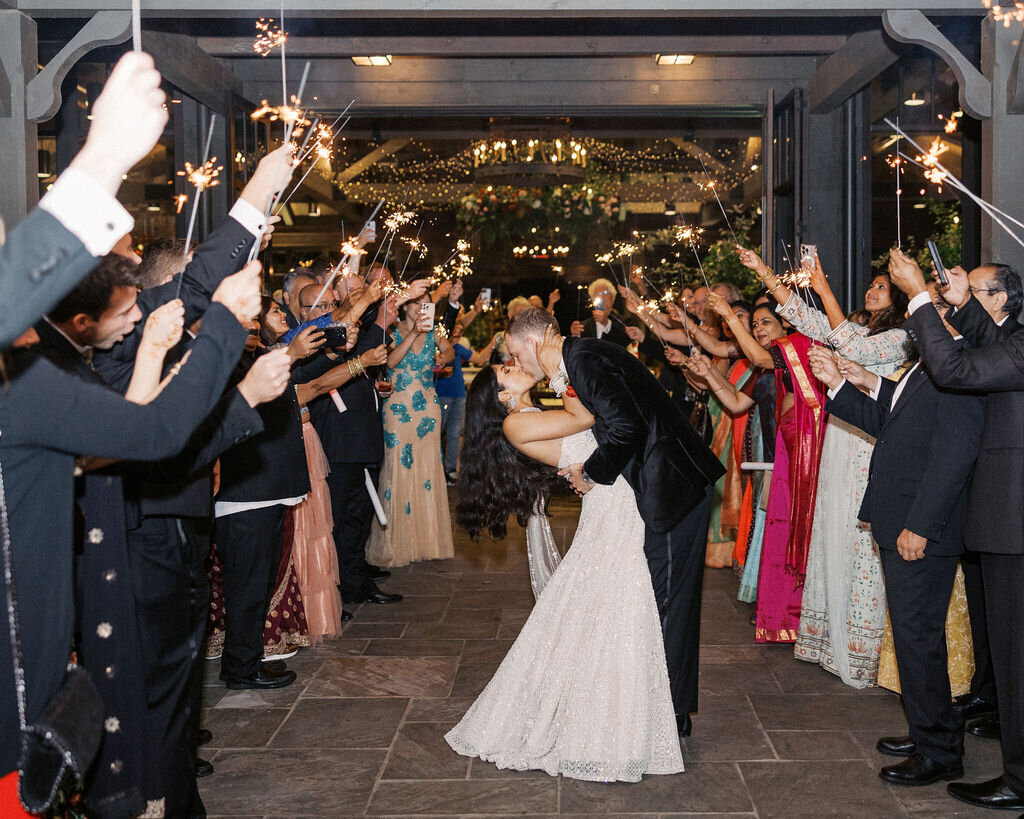 The groom dips the bride for a kiss during their sparkler exit at Old Edwards Inn in Highlands, North Carolina.