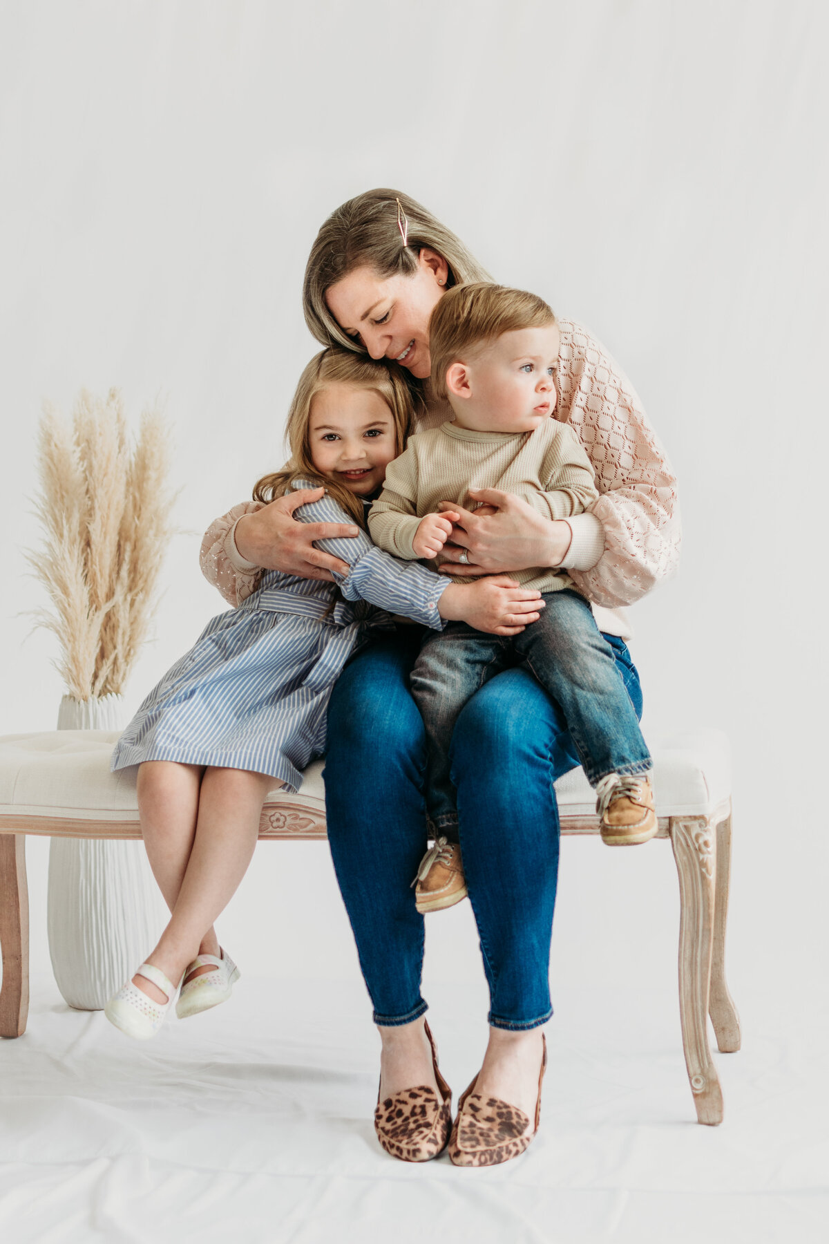 Mom hugging her children during a motherhood photo session in studio in Bartlett, IL