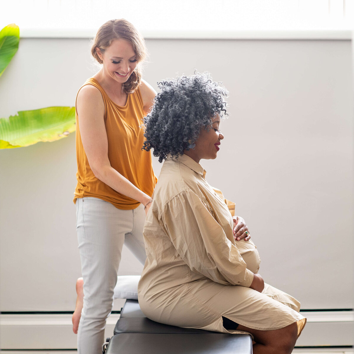 photo of chiropractor adjusting a pregnant mom's spine.  Captured by Ottawa Branding Photographer JEMMAN Photography Commercial