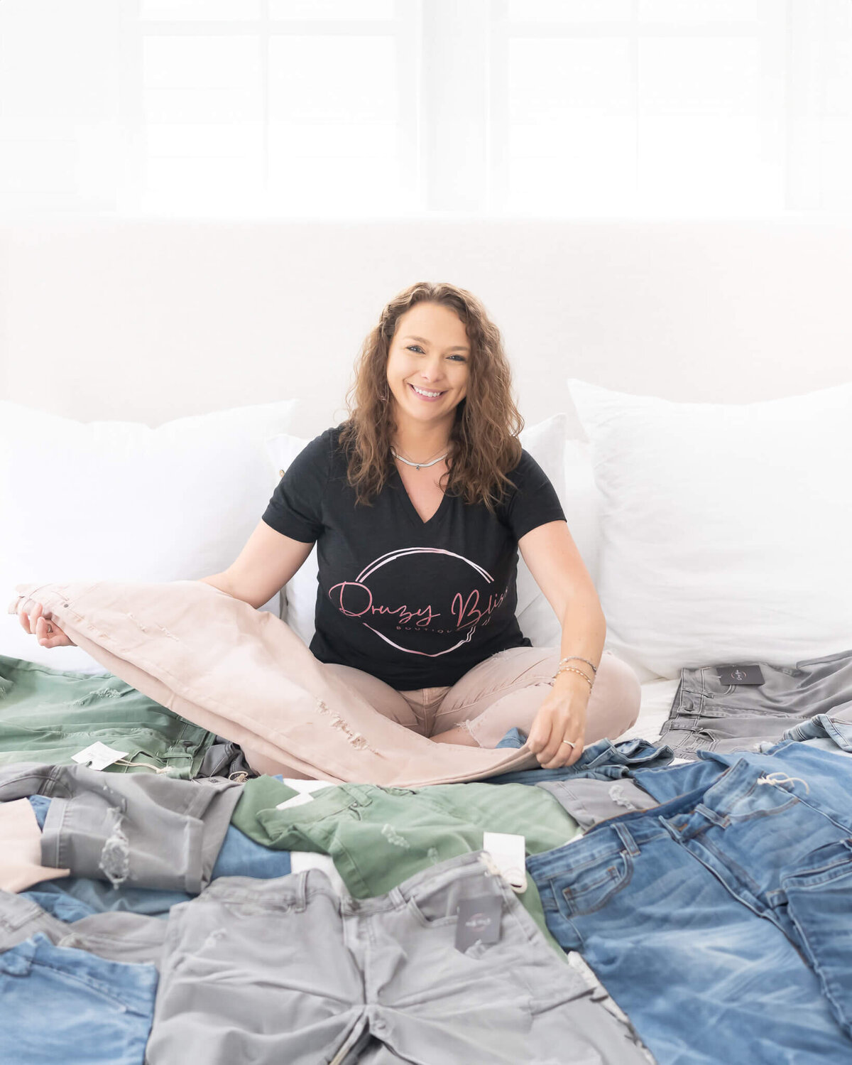 Boutique owner surrounded by all the jeans she loves to sell