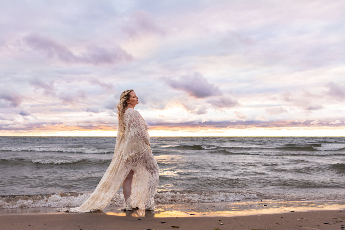 mother standing in lace dress by the waters of lake ontario