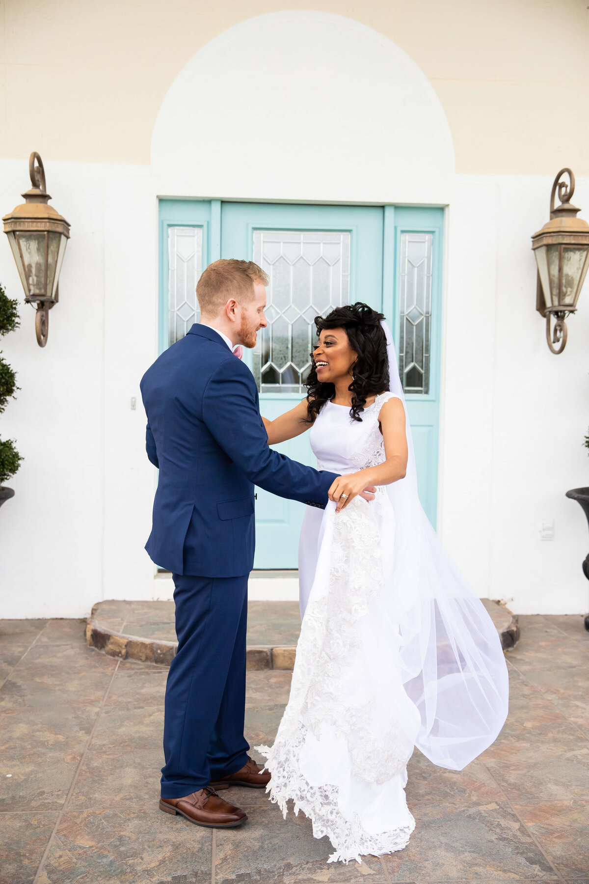 Bride and groom first look outsdide house with blue door