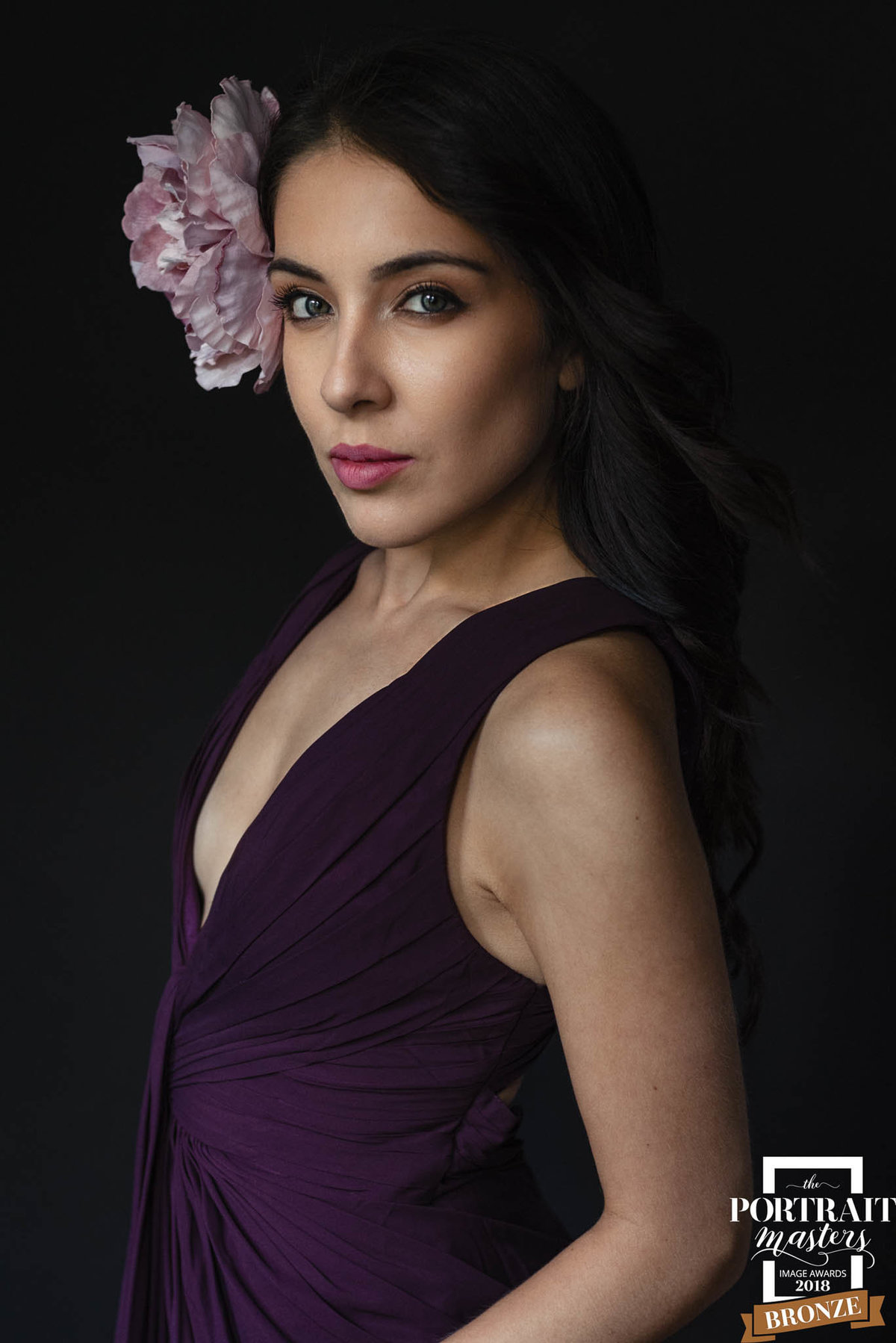 beautiful lady with purple flower in  hair in gorgeous purple dress for portrait session