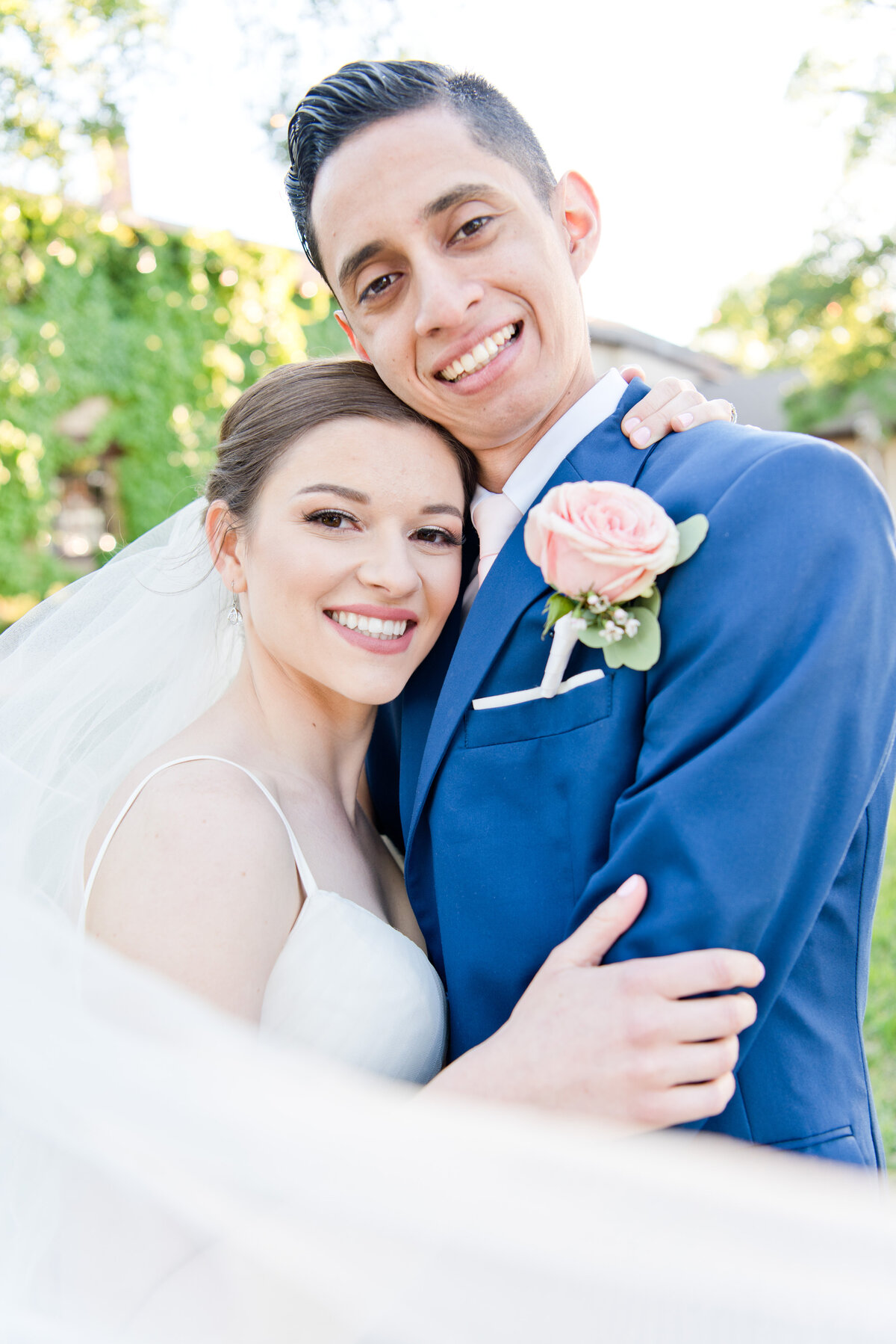 Bride and Groom embracing with veil swooped around them in Fort Worth