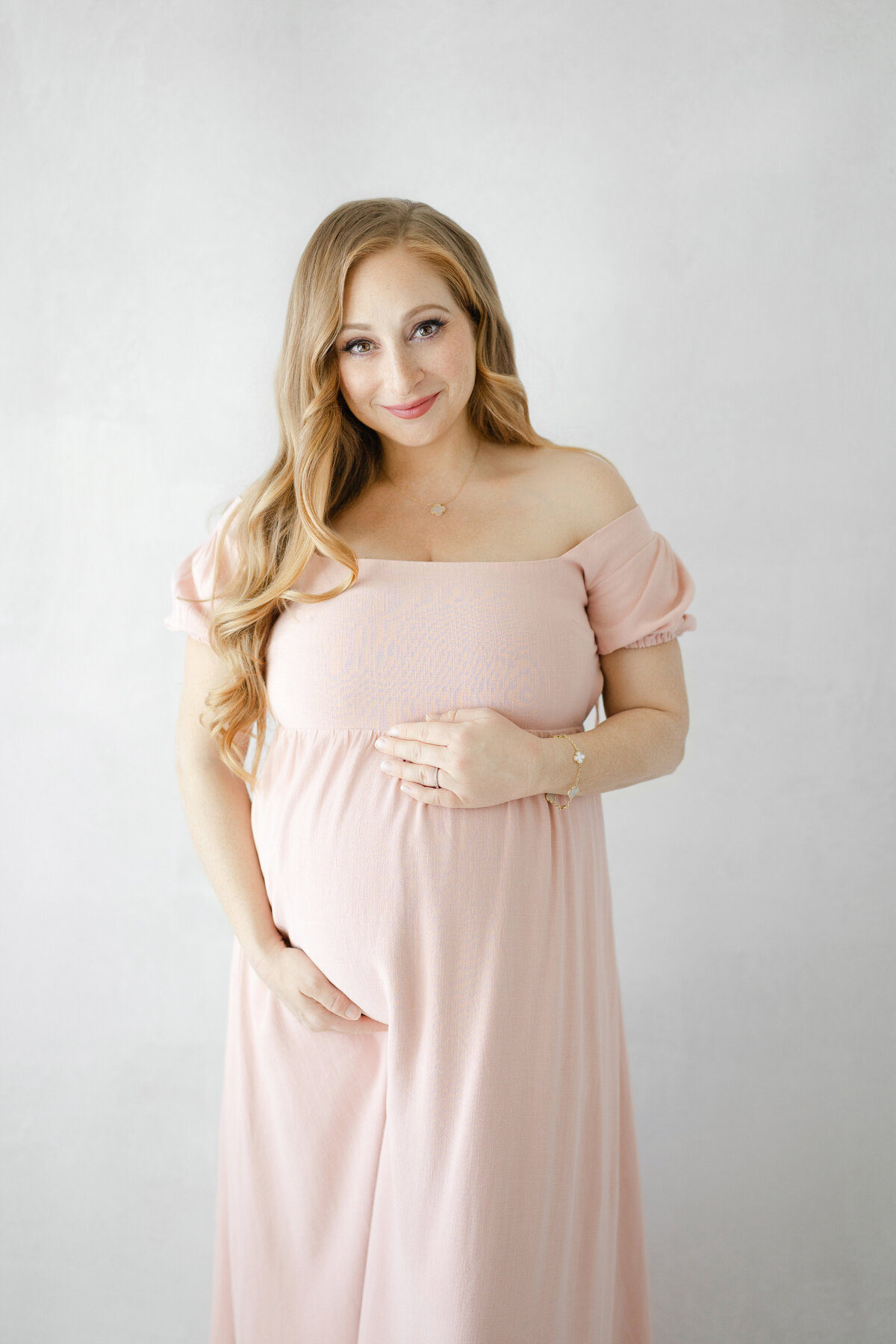 Elegant maternity portrait of Christina with natural light pouring in during Tampa studio session