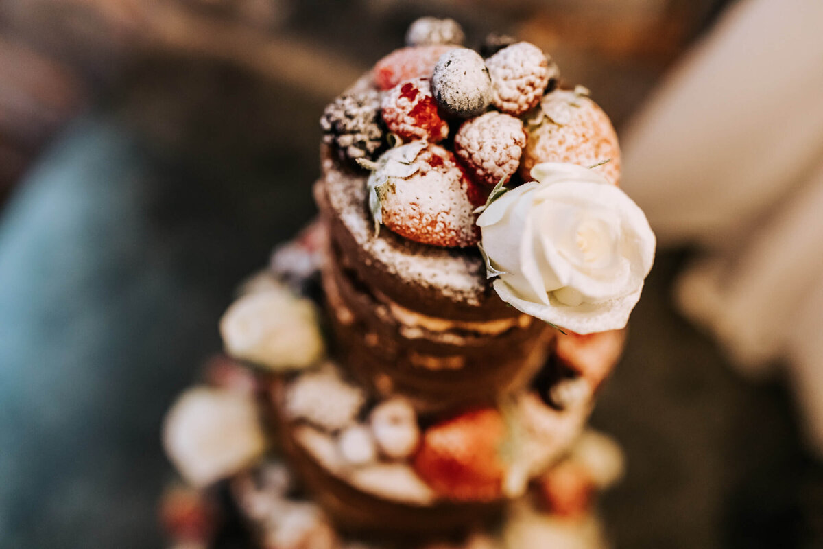 A close up of a wedding cake covered in powdered sugar