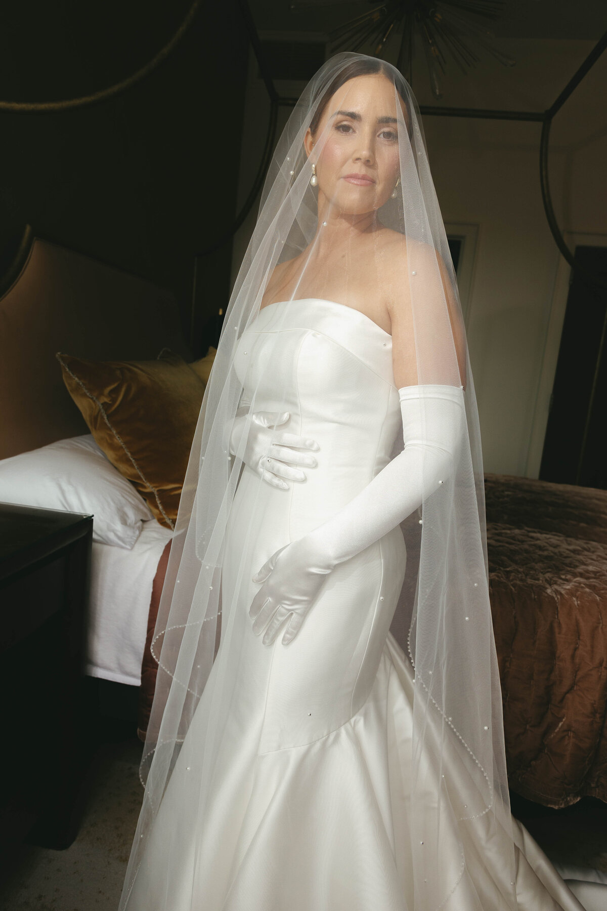 Elegant bride in satin gown and veil before Arkansas wedding
