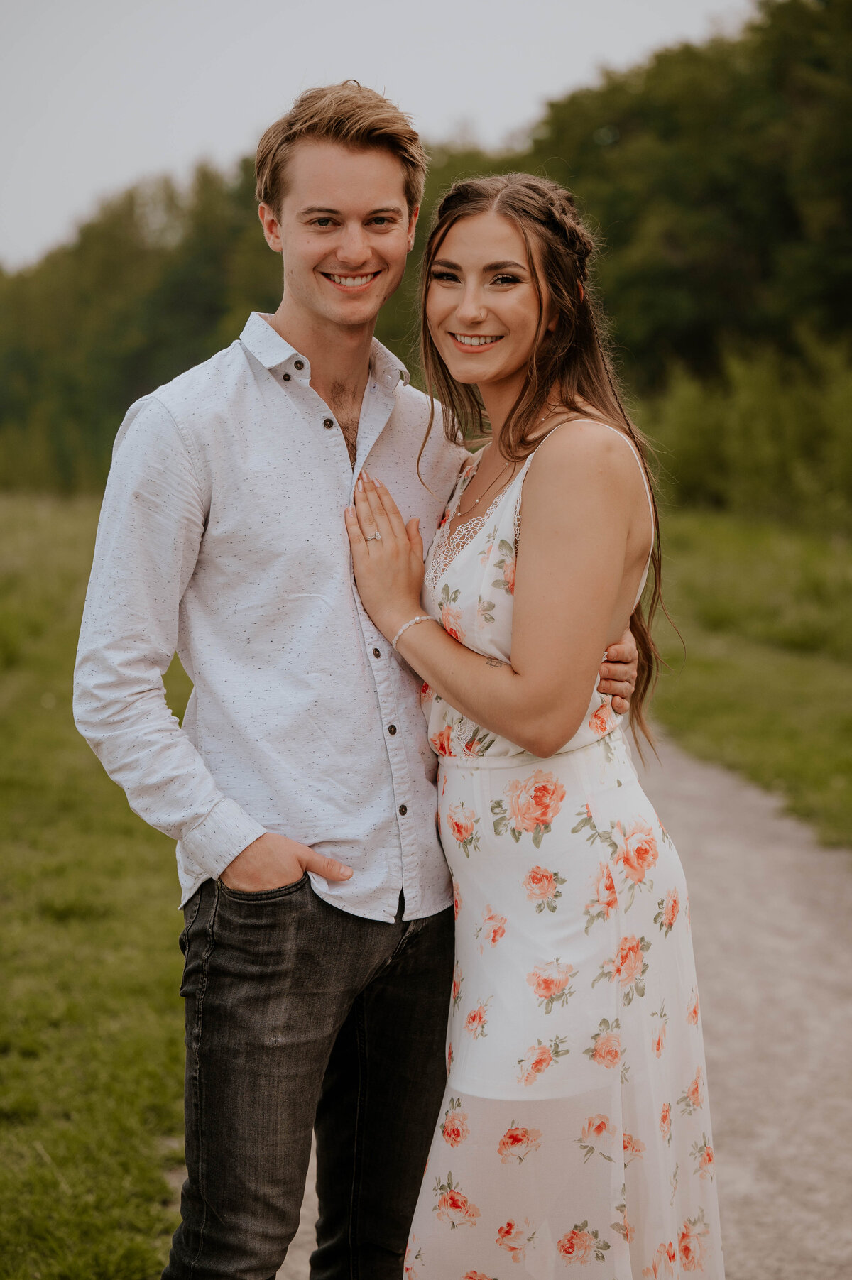 Engaged couple posing for photo in Alberta field