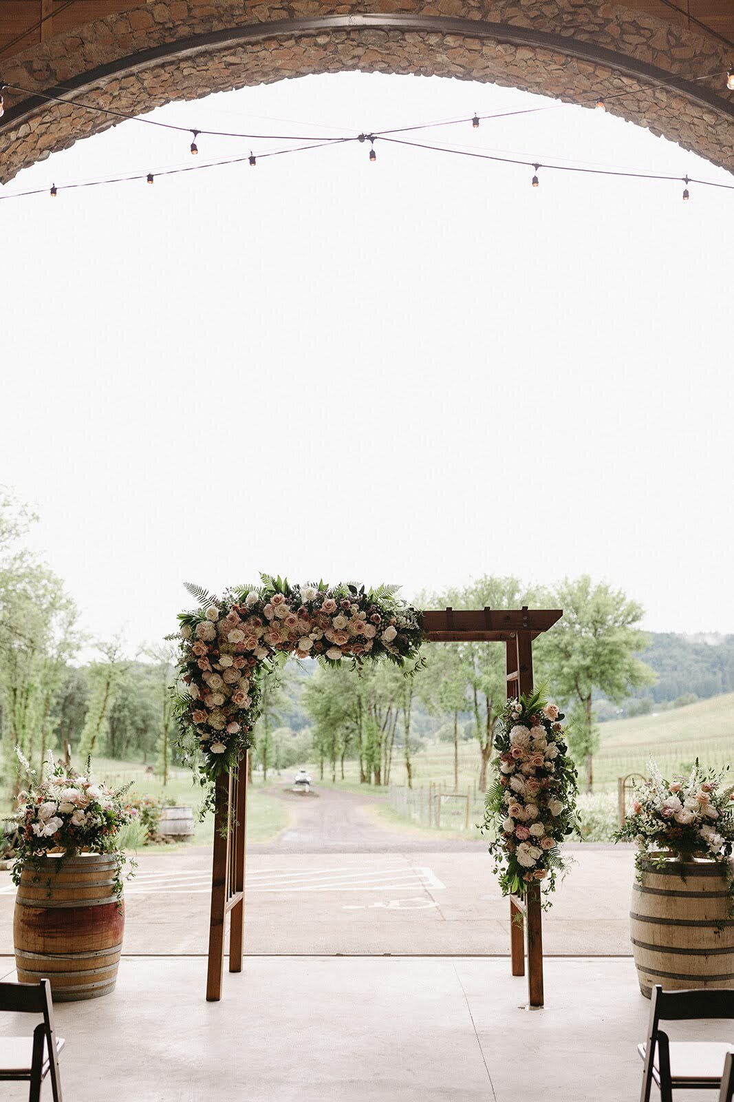 Floral arch installation and large floral centerpieces by Flowers and Thyme for wedding at Maysara winery.