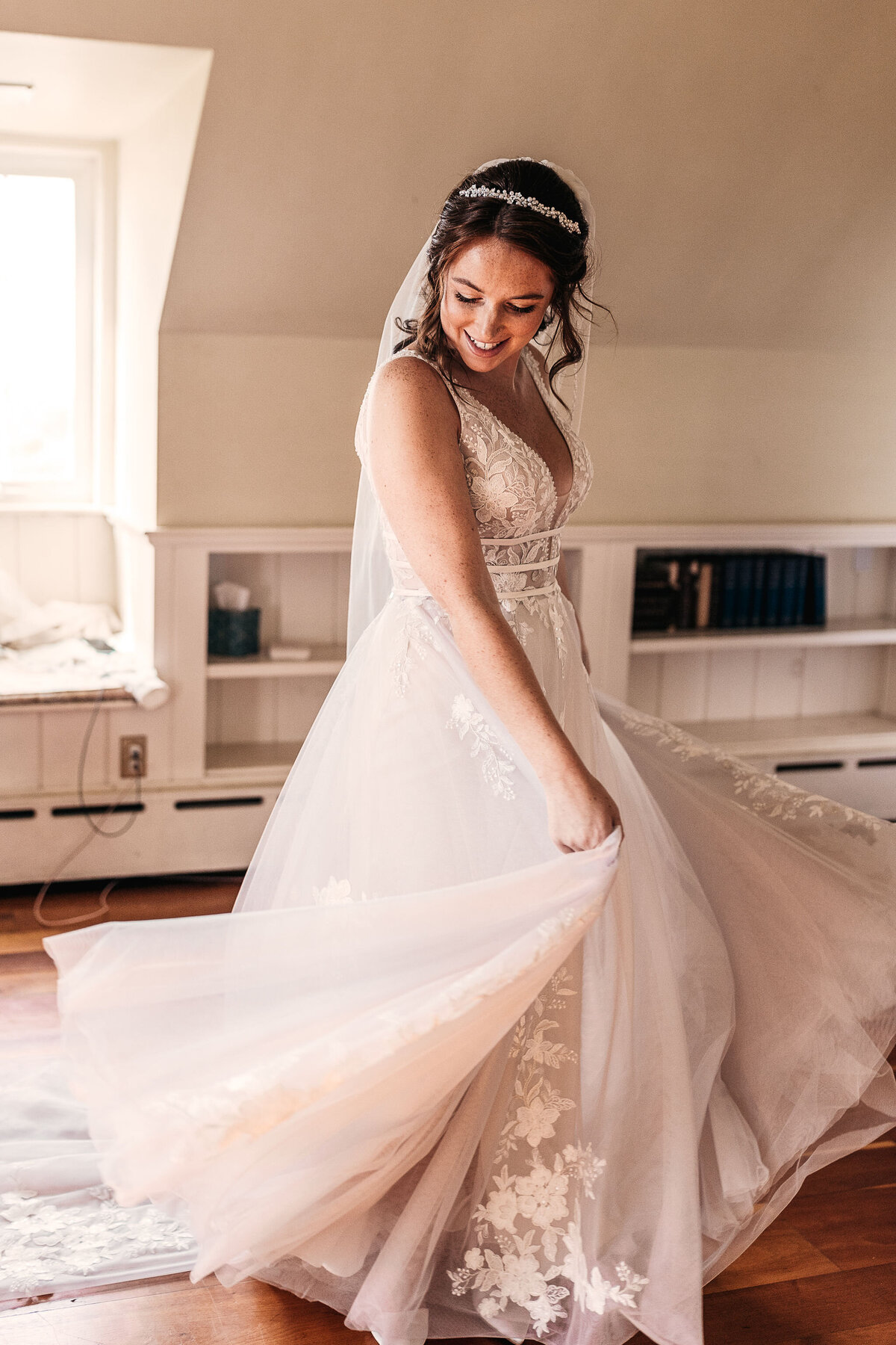 Bride swinging her gown while getting ready in bridal suite at Cobb Hill in NH By Lisa Smith Photography