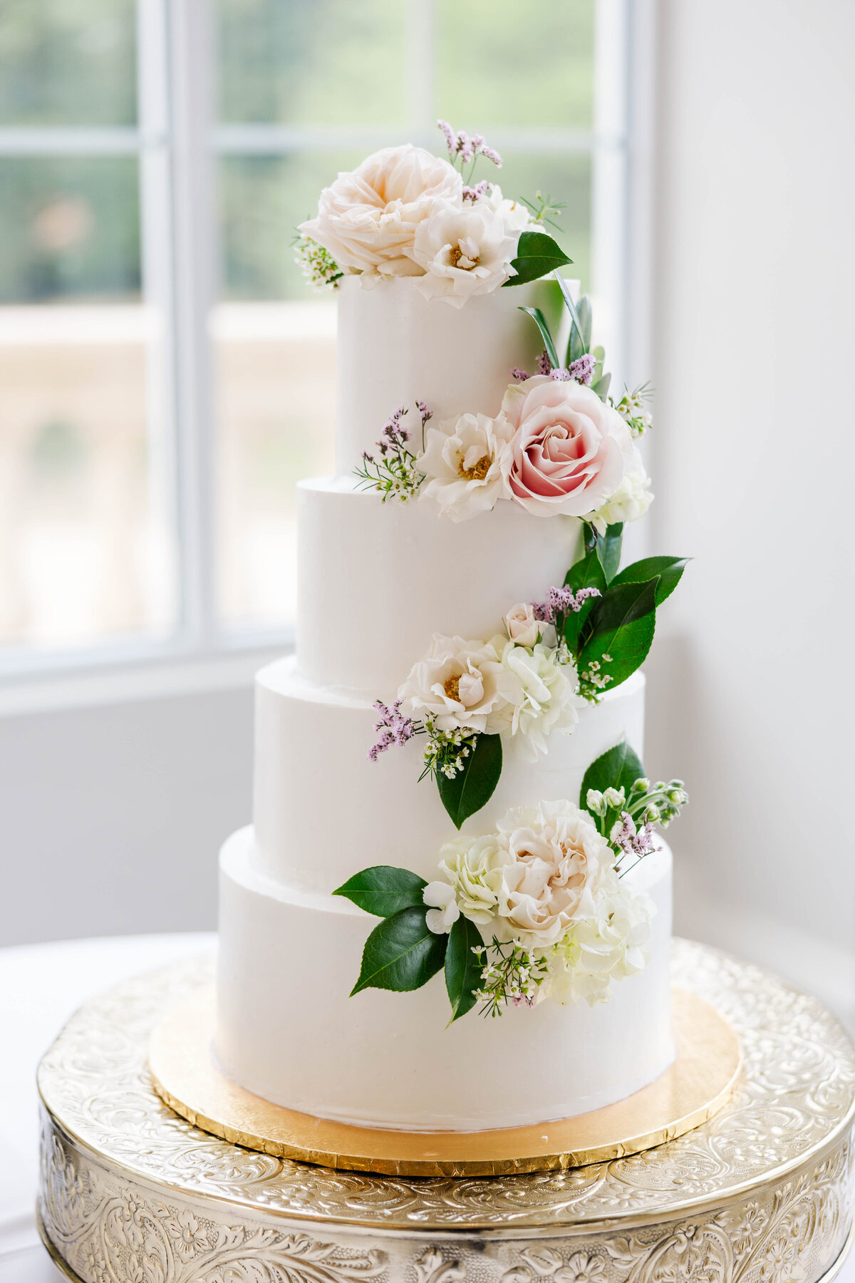 four-tiered-white-wedding-cake-with-fresh-pink-flowers