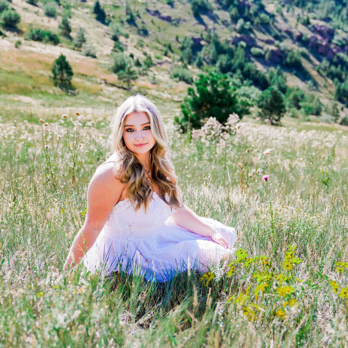senior photography denver - teen girl in white dress sitting in field
