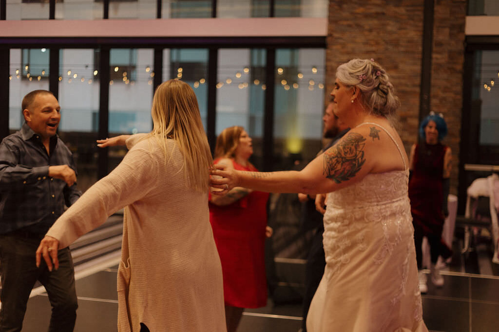 A newlywed dancing with wedding guests.