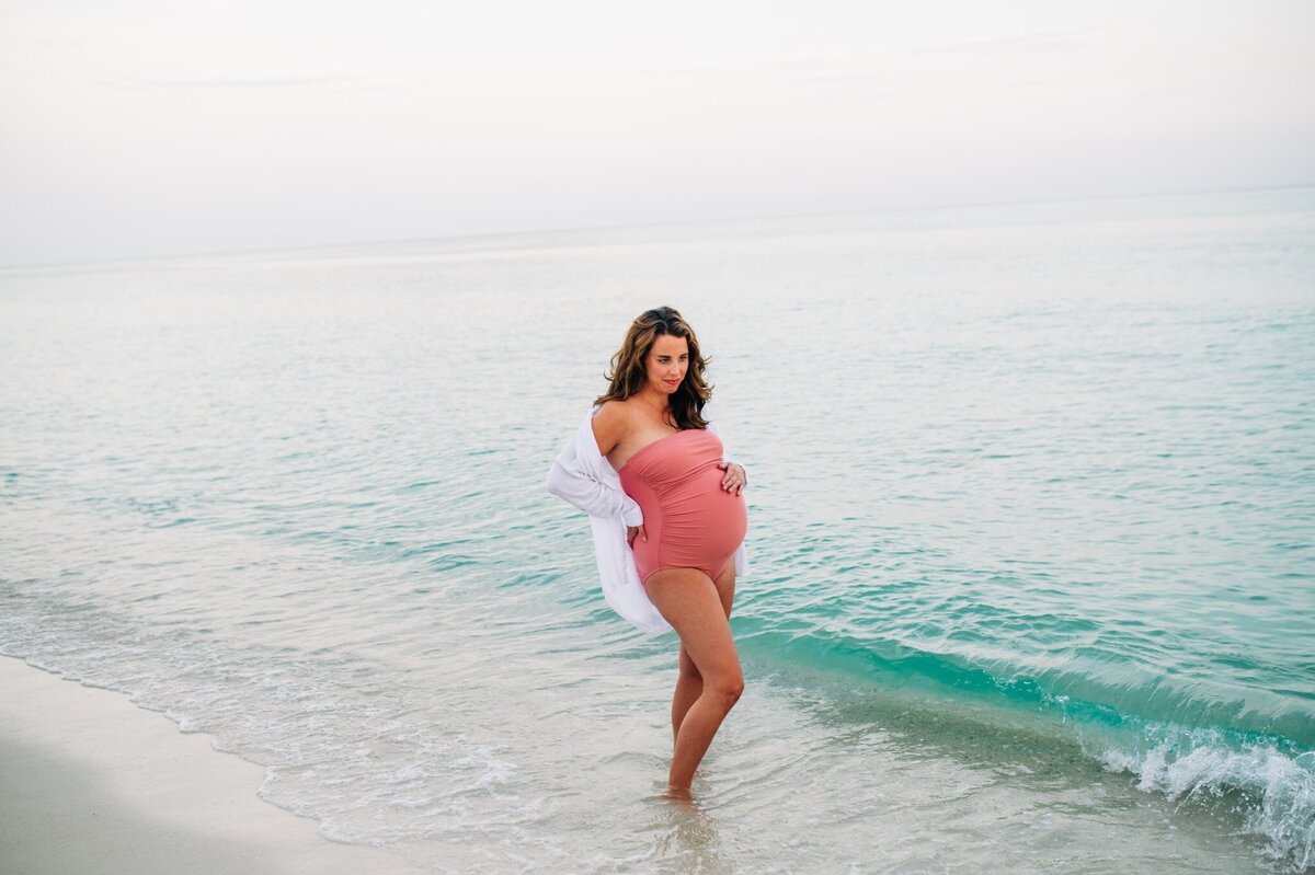 mom pregnany in bathing suit by ocean in Pensacola  Beach