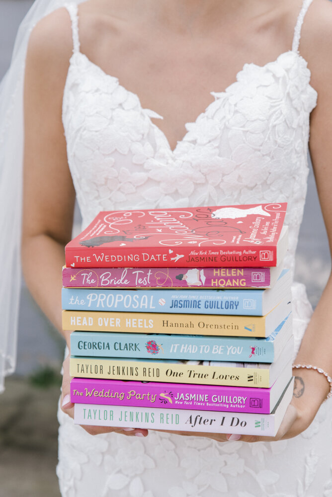 bride carrying a stack of books