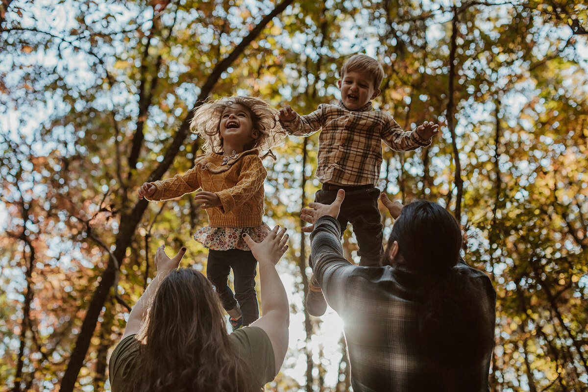 parents toss twins in the air and they laugh