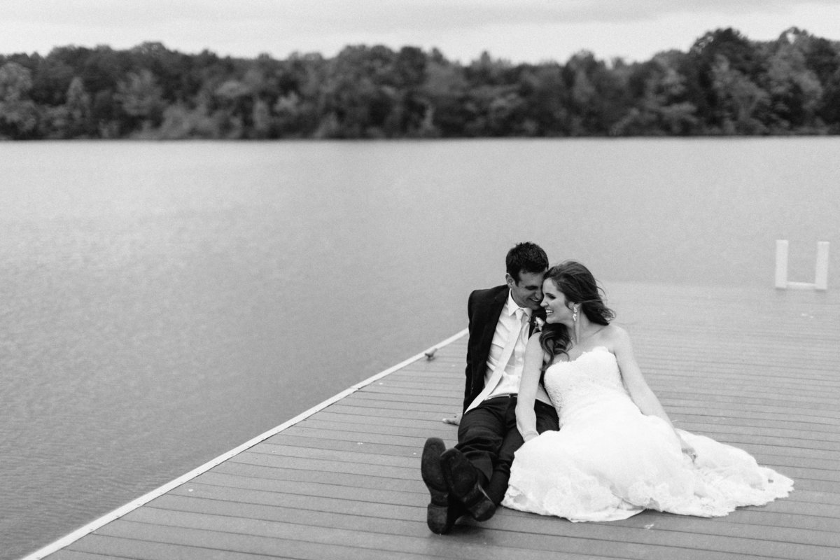 couple sitting on dock at waterfront wedding venue