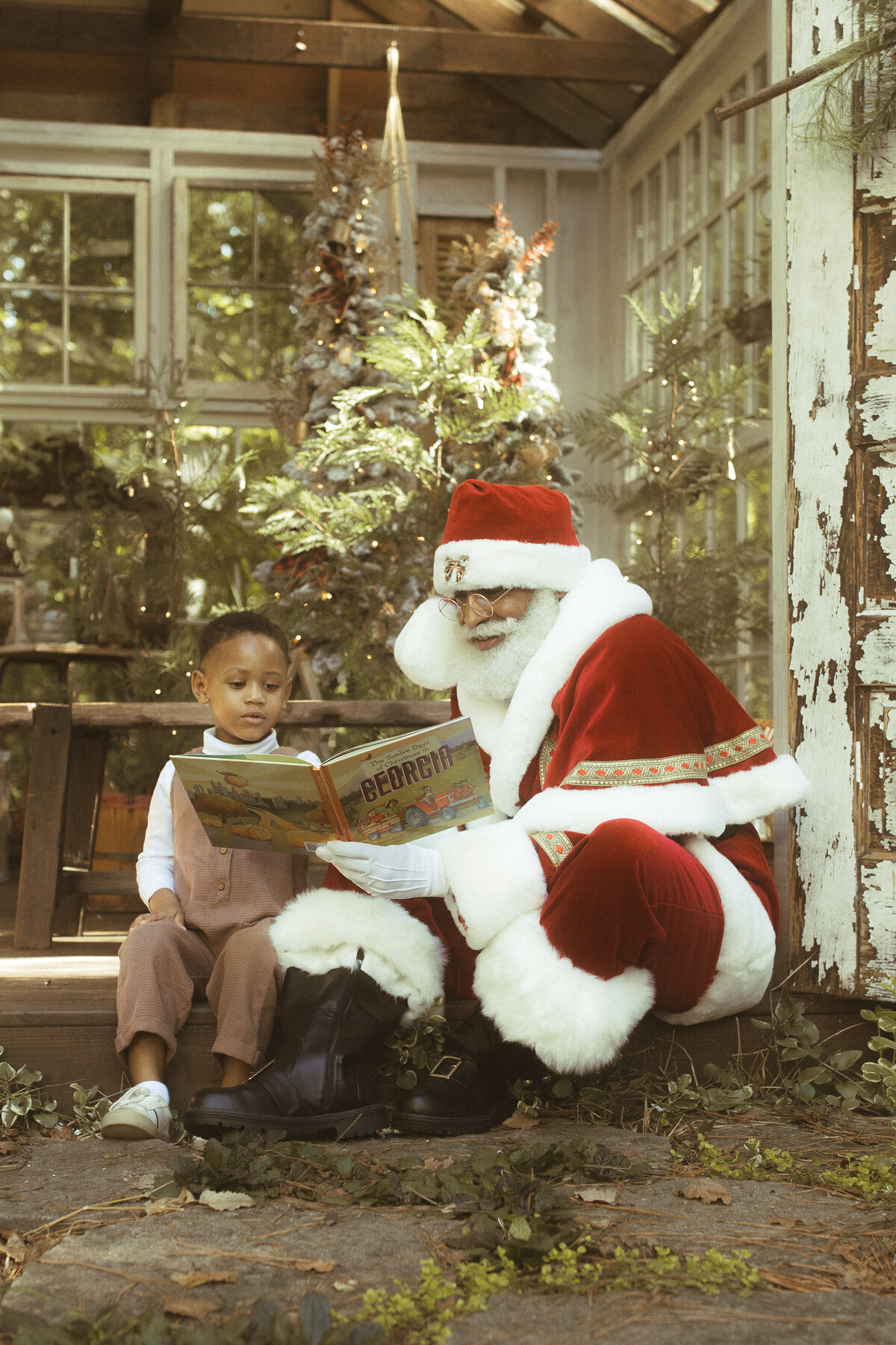 Santa reading a book to a little boy at Das Hinterhaus.