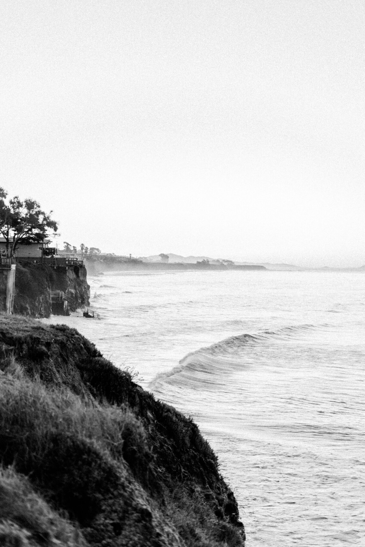 Black and white image of a rugged coastline, symbolizing Christine Grace’s emotionally grounded approach to photography.