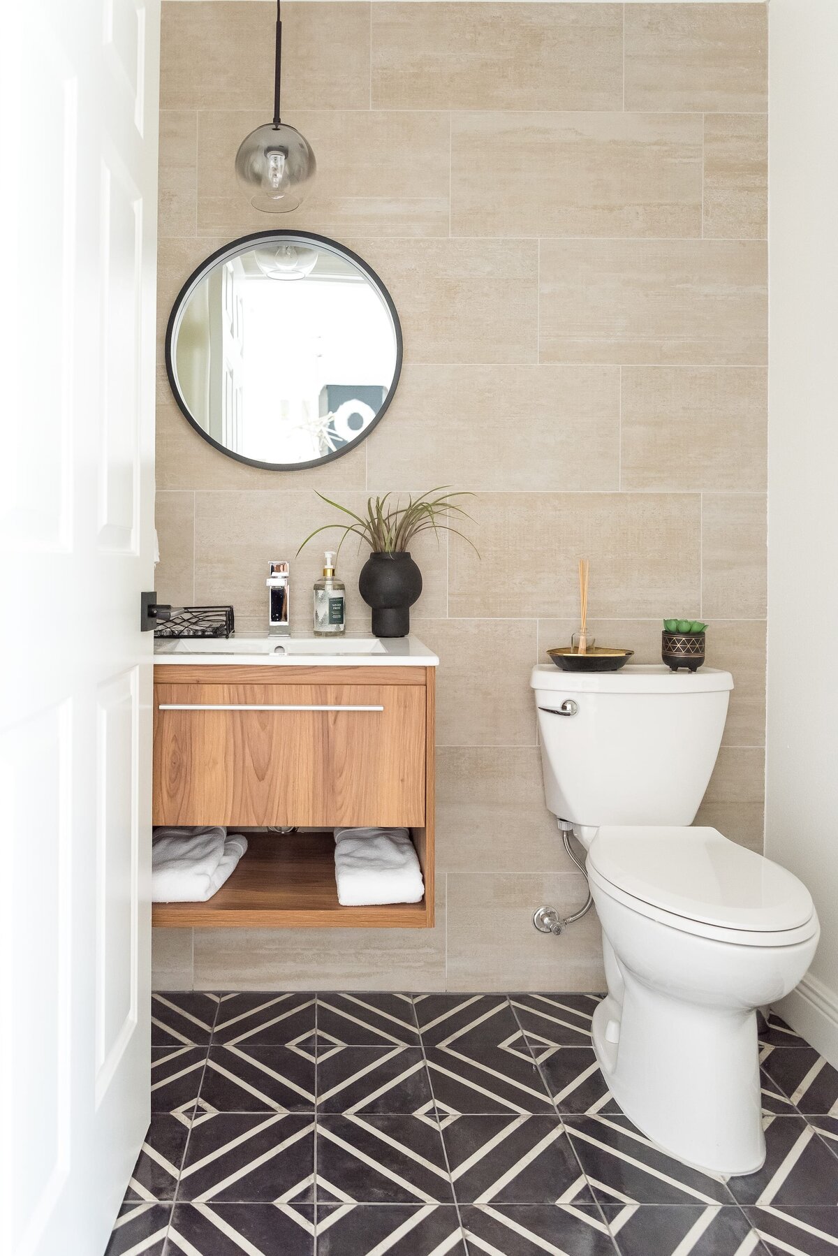 dewine design orlando interior designer modern lakehouse bathroom with accent tile flooring and round mirror