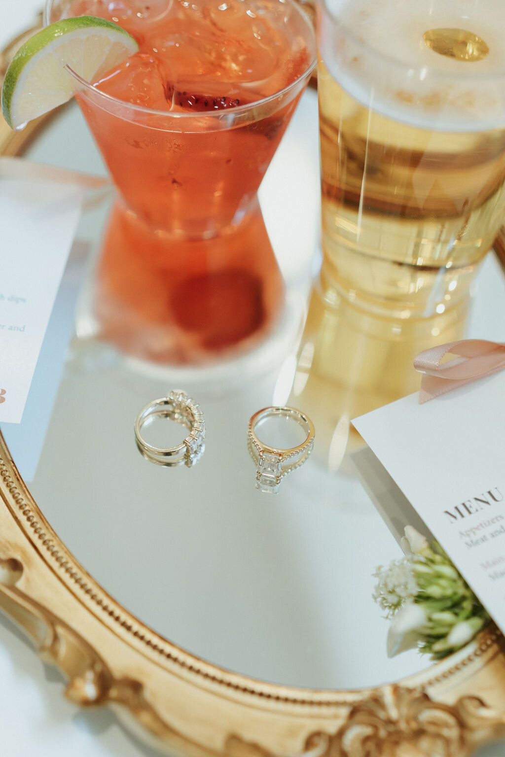 custom wedding flat lay on mirror tray with signature drinks, rings and custom menu cards with satin ribbon detail
