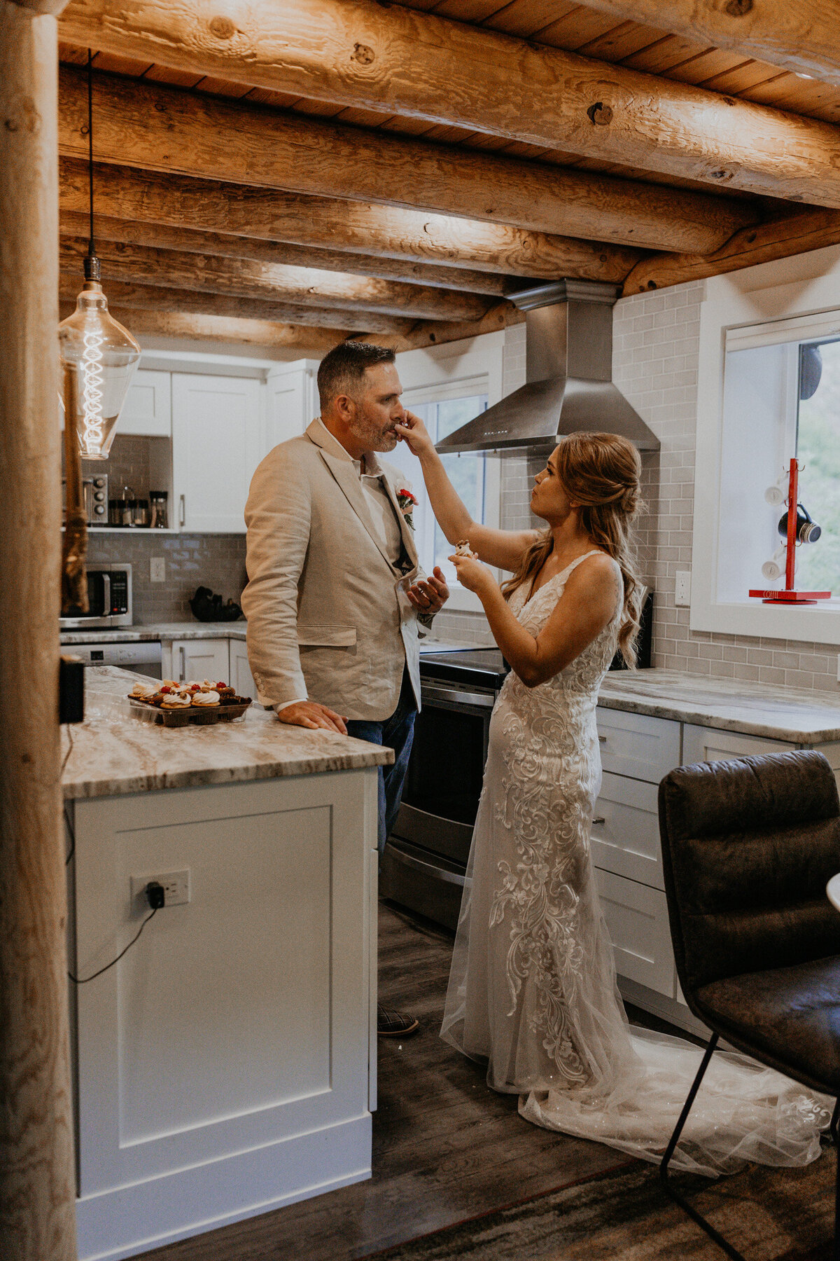 newlyweds enjoying cupcakes together in their kitchen after their ceremony