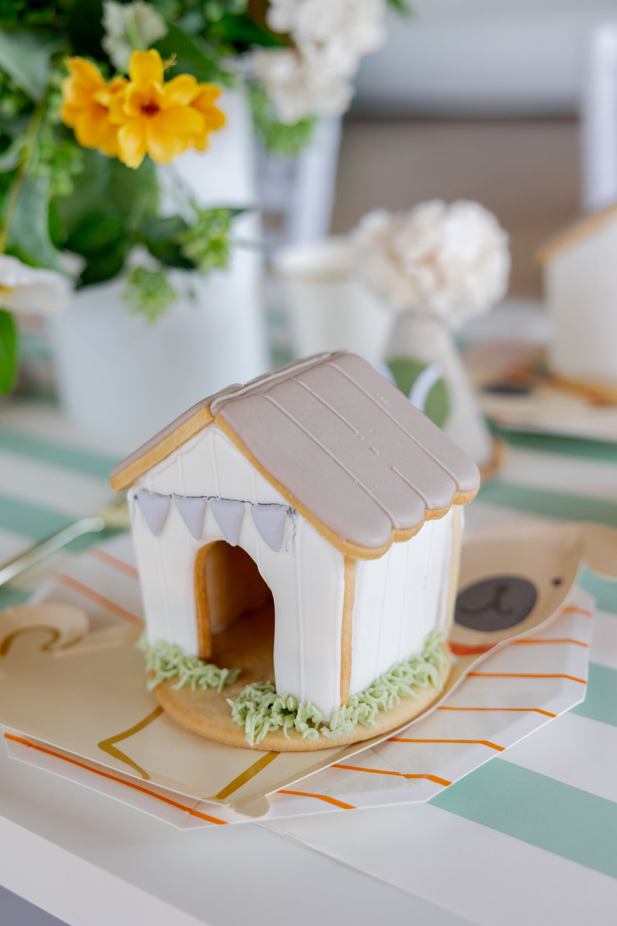 Unique dog house cookie on dog paper plate. 