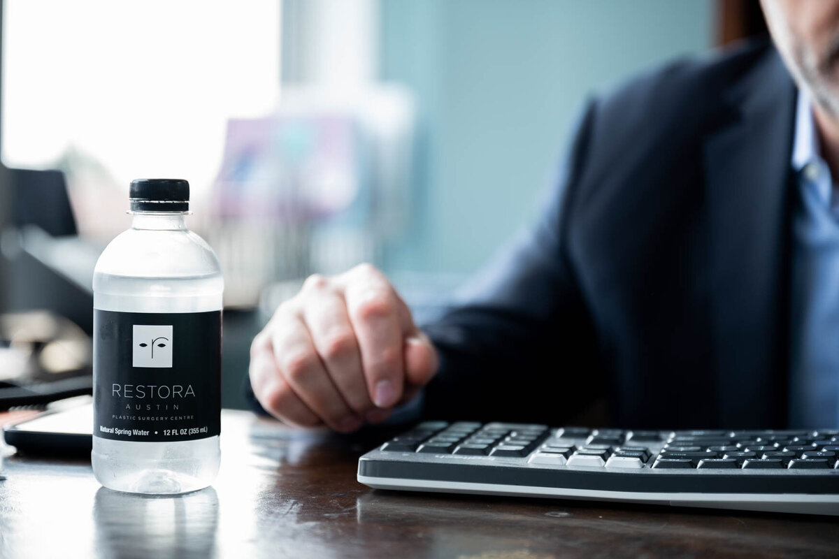 A image of a bottle of water on a desk next to a computer board