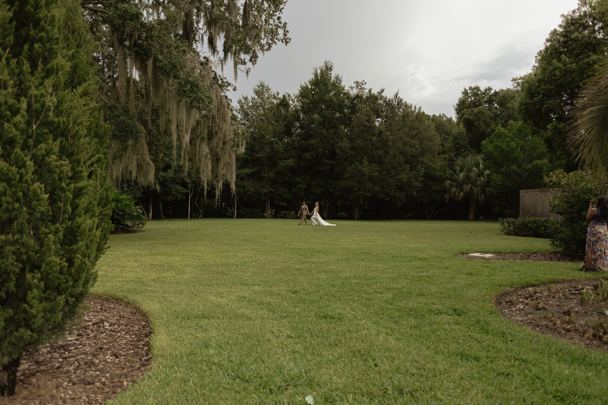 Intimate Florida wedding ceremony in the backyard of The Palm Mansion with soft florals and palm tree views