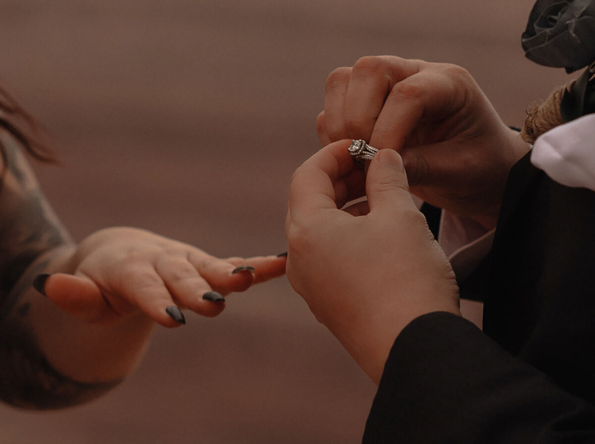 Elopement couple exchanging rings while getting married in Moab, Utah