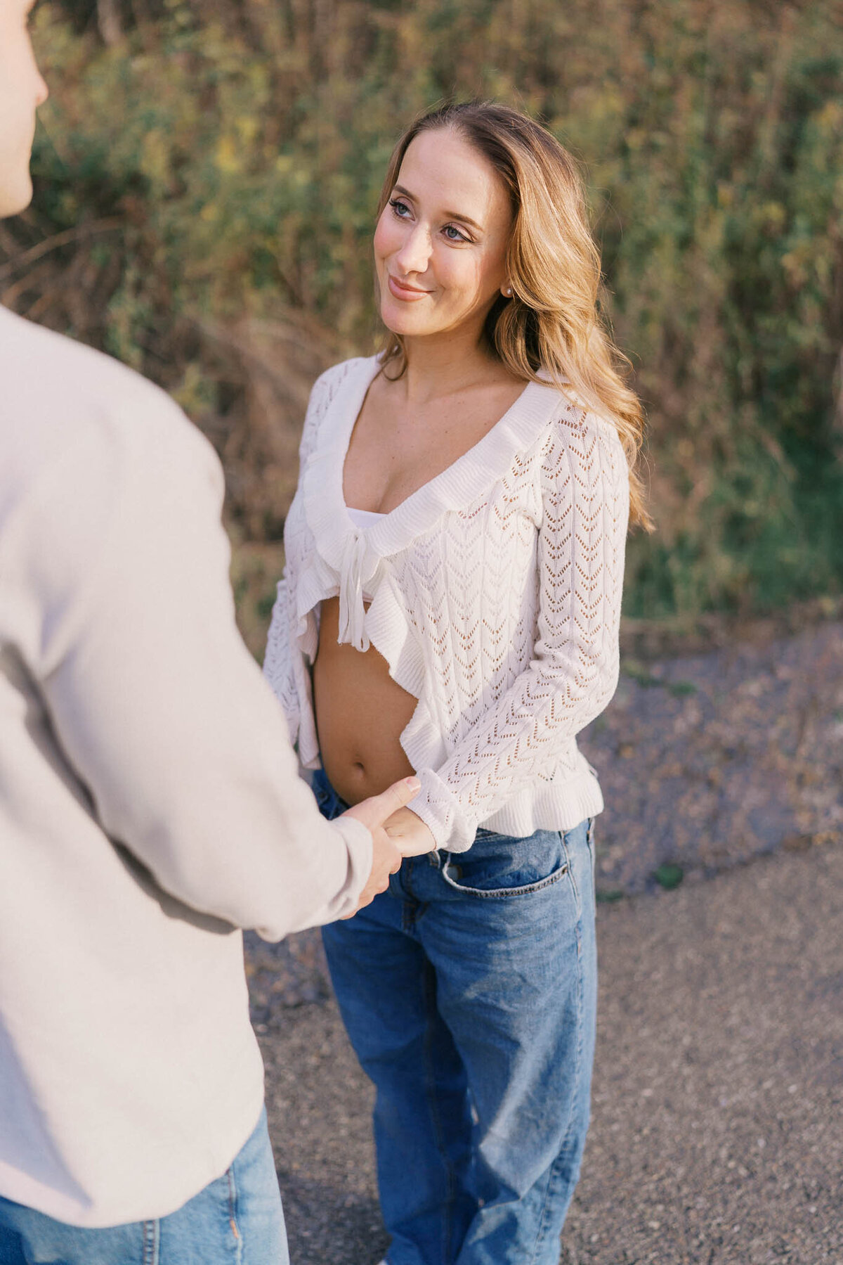 pregnant woman holds hands with husband at golden hour in knoxville tennessee