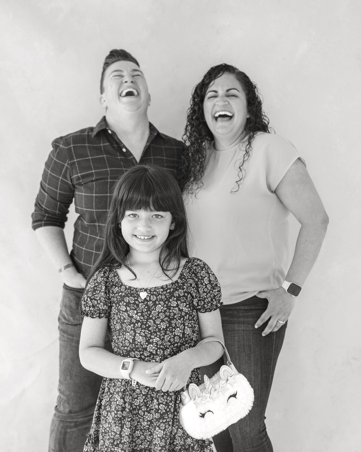 Mothers  laughing in studio portrait with their daughter