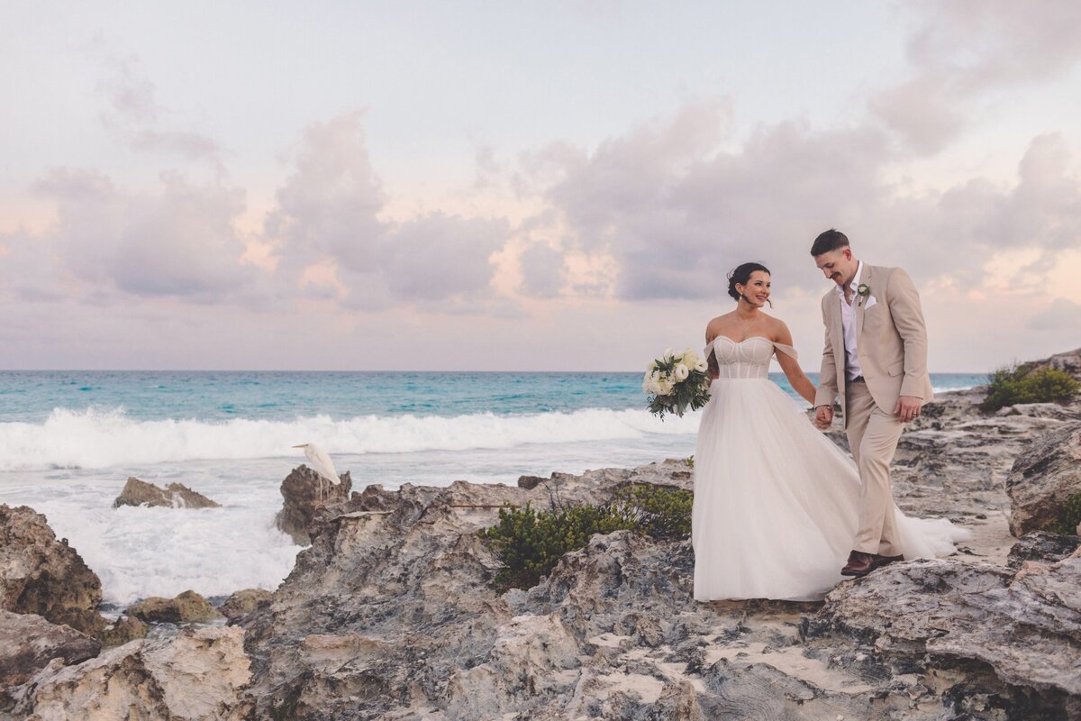 Bride and groom walk in the rocks near Hyatt Ziva Cancun wedding