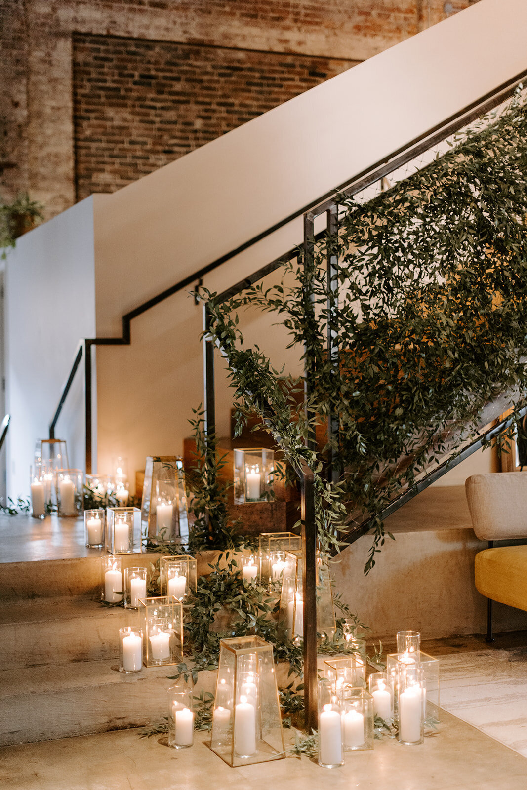 Wild Carrot wedding venue adorned with greenery and candles next to staircase