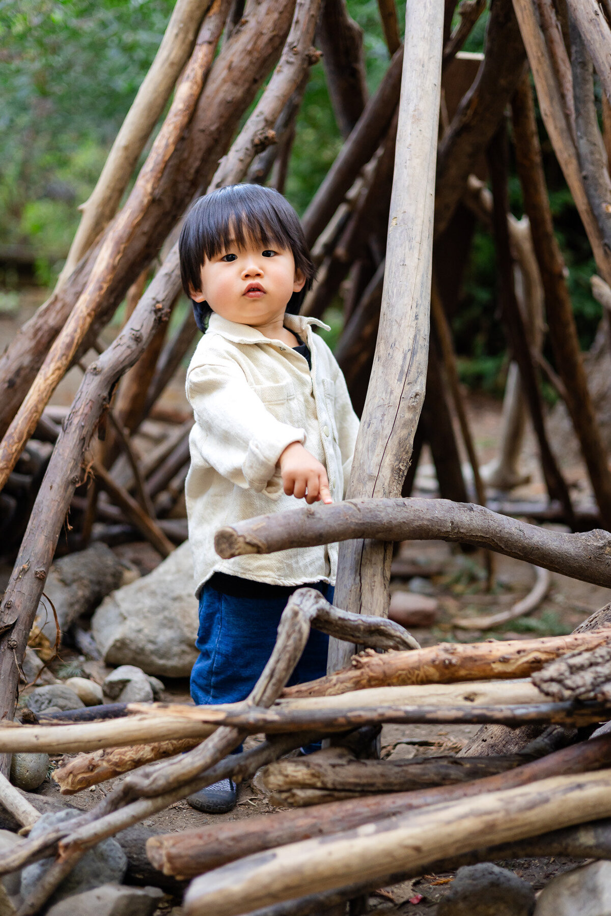Curious child exploring wooden teepee structure during Bay Area School Photography Lifestyle session – Ellobelle Photography
