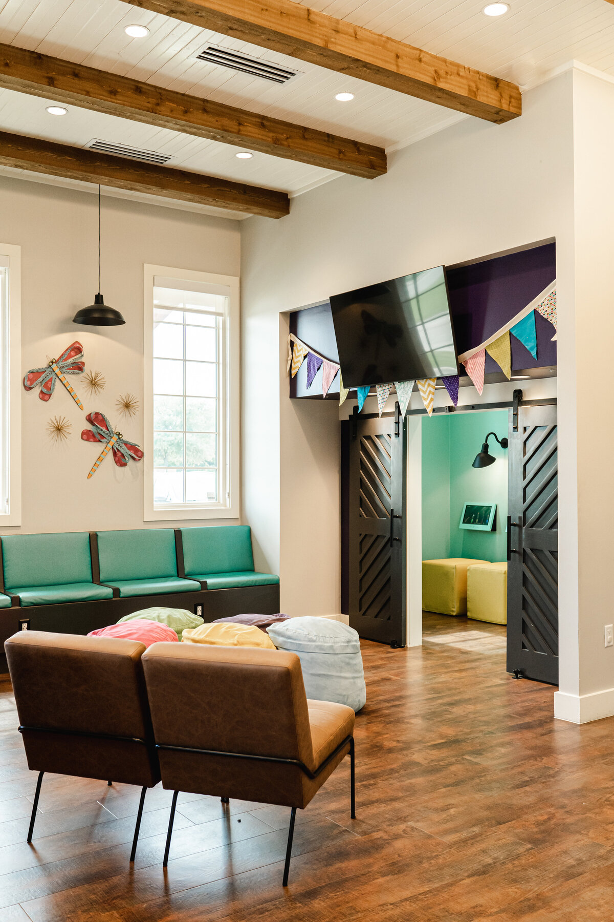 dentist office lobby with sliding barn doors and wood flooring