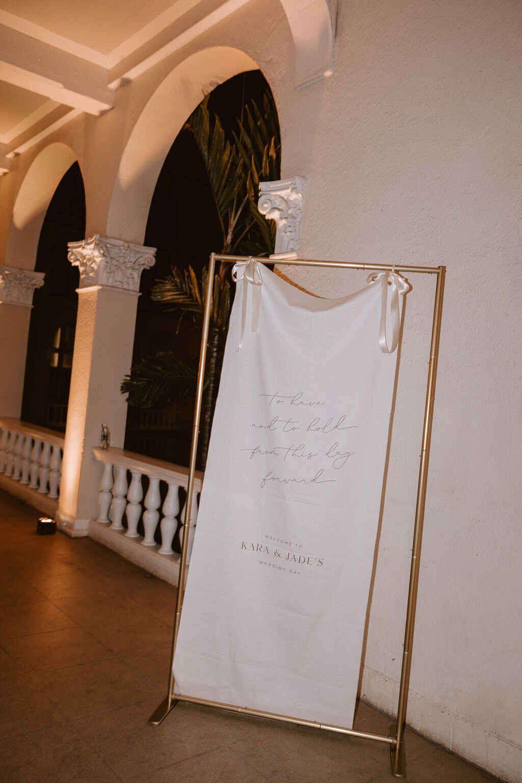 Welcome sign with candlelit lighting, sign is hanging from ribbons and is made of canvas