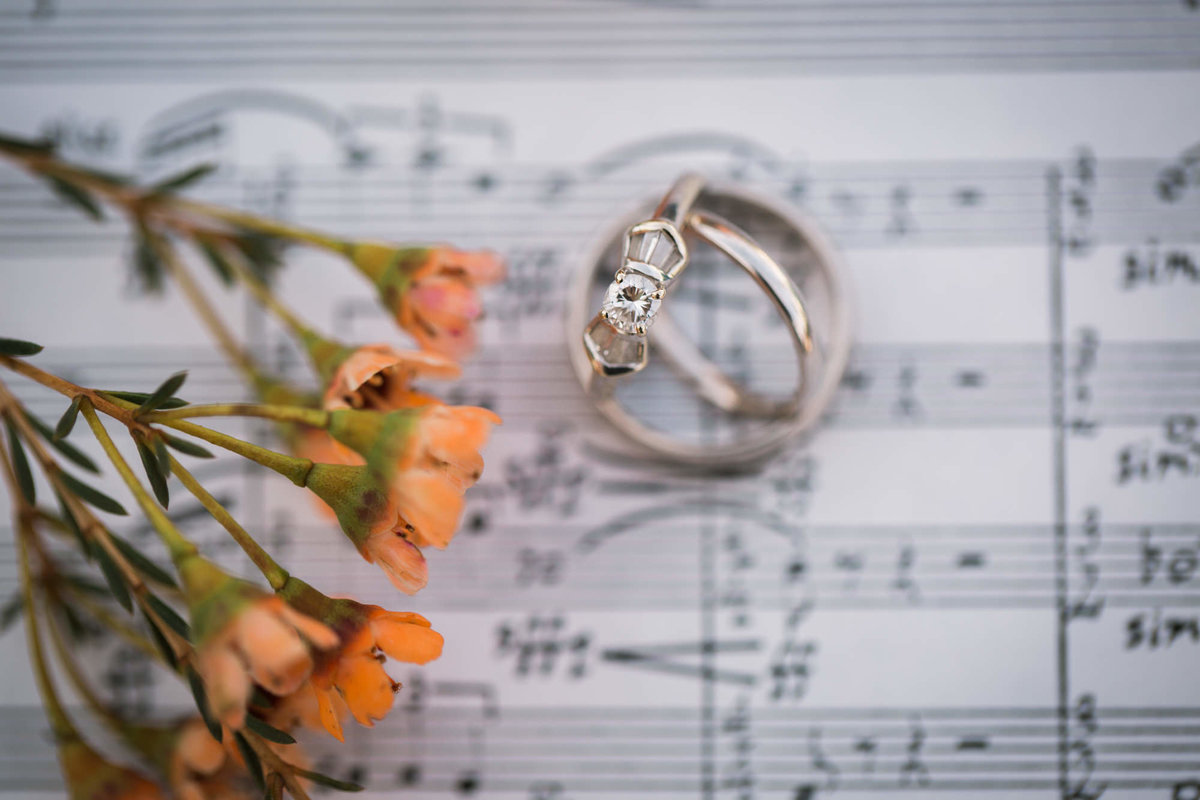 Bride and Groom's wedding rings sit together on a sheet of music