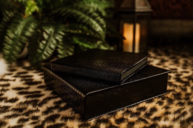 Boudoir photography black keepsake albums on leopard rug  in Lubbock, Texas photographer in Amarillo TX
