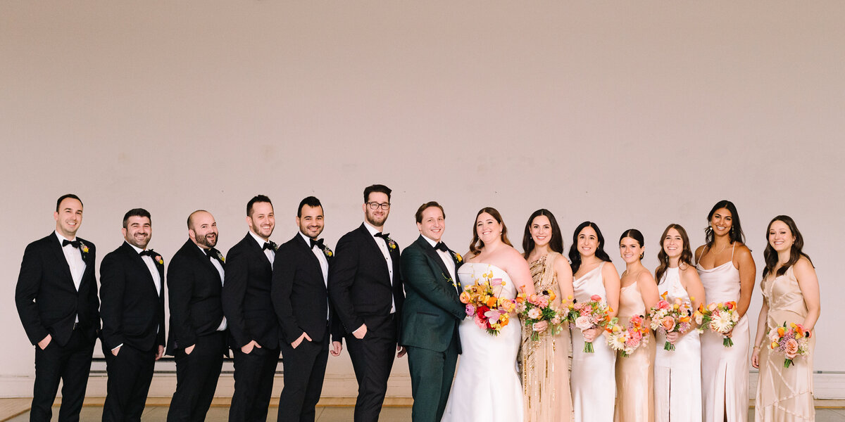 A wedding party pose at the Rialto Theatre, with the bridesmaids holding bright bouquets.