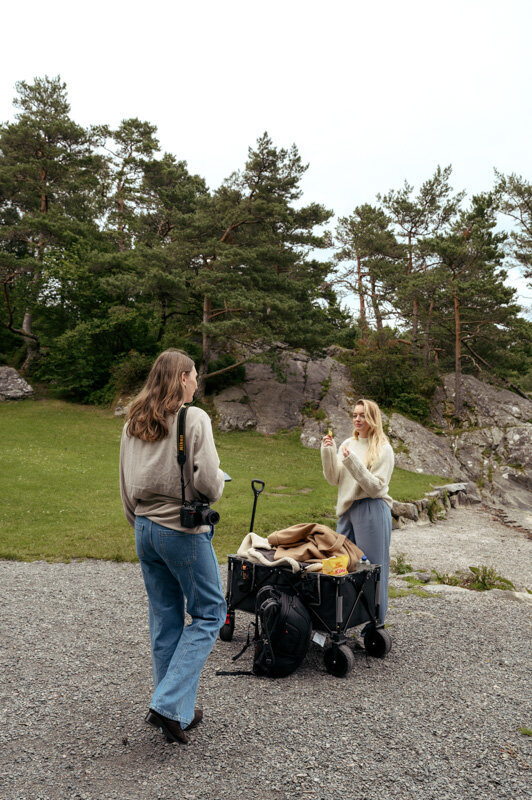 Two female are working on a photoshoot with equipment and clothes