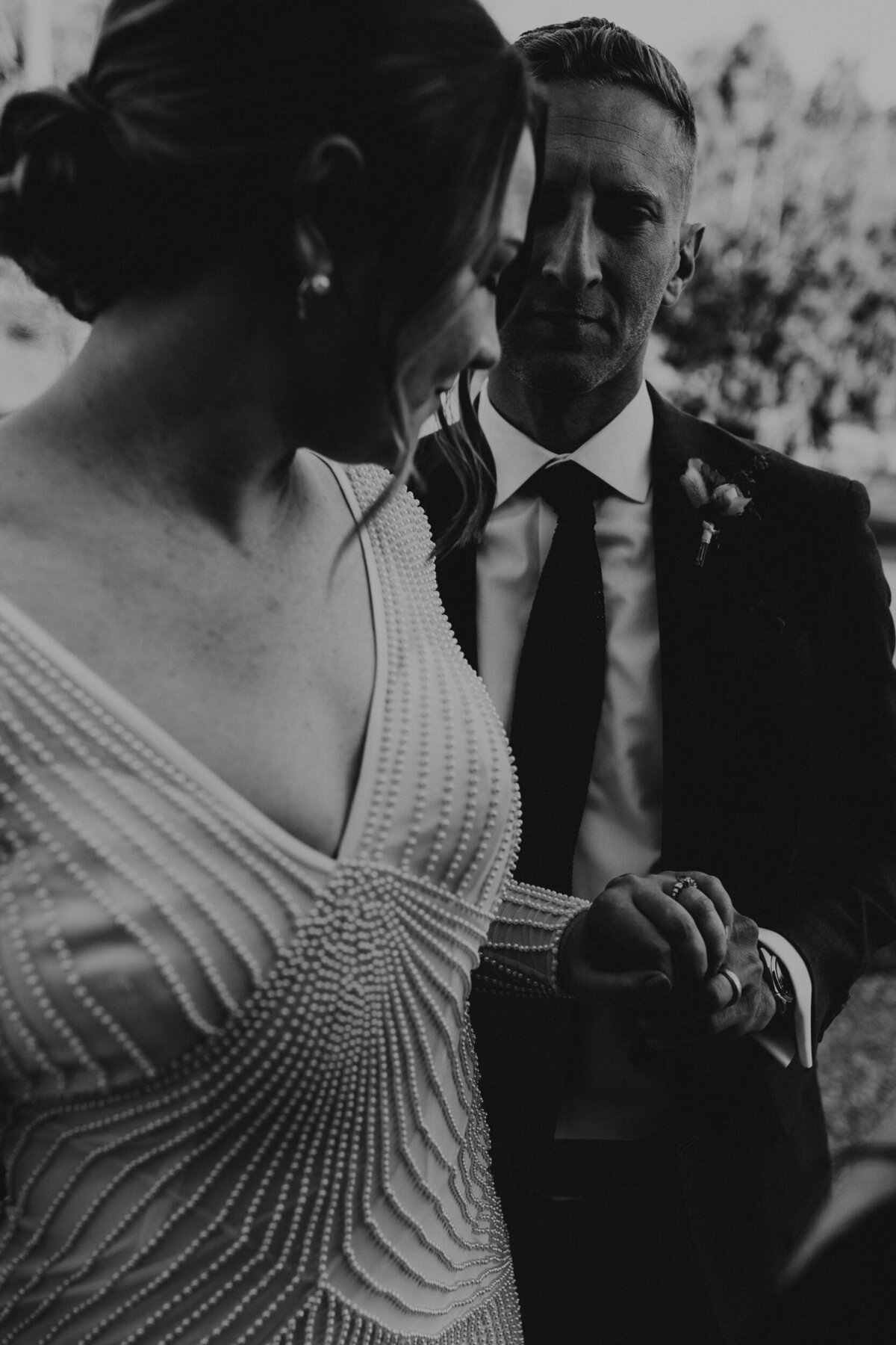 bride and groom holding hands in black and white