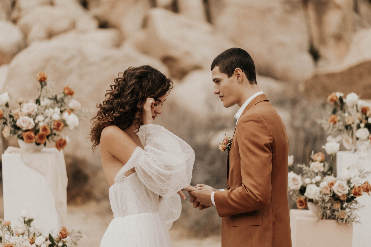 Emotional bride and groom exchange vows in desert