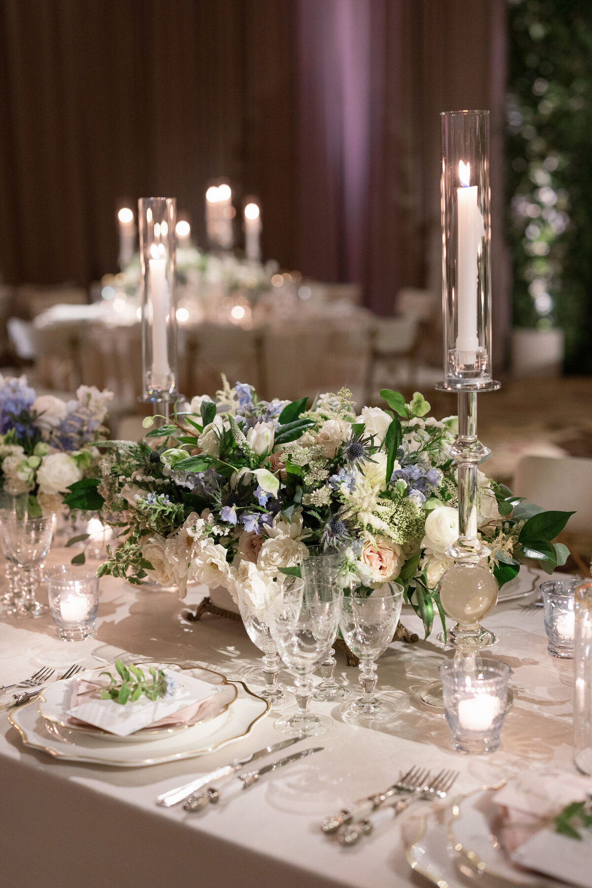 Close up of the wedding flower arrangements and candles on a table. 
