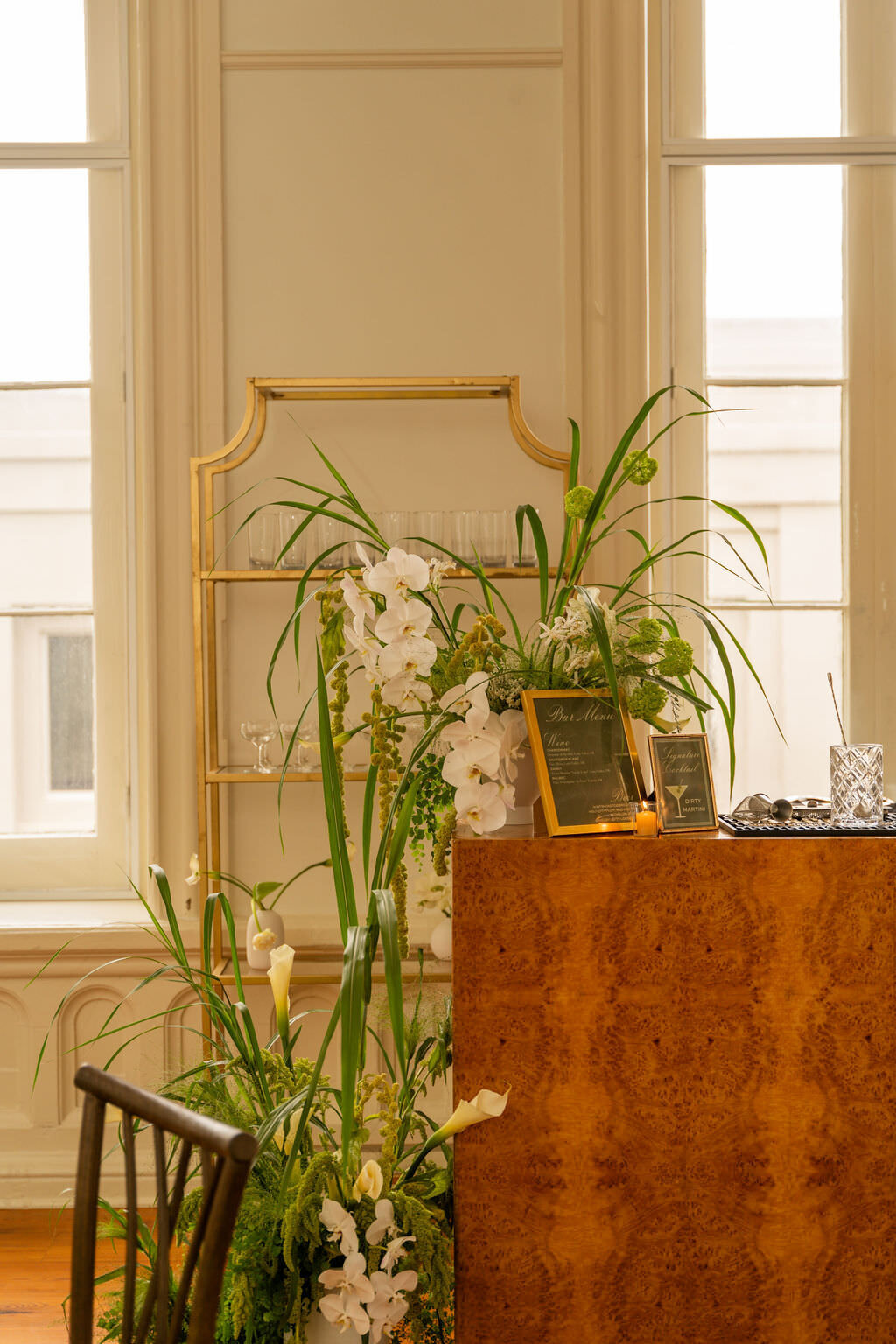 Lush wedding florals surrounding event reception bar