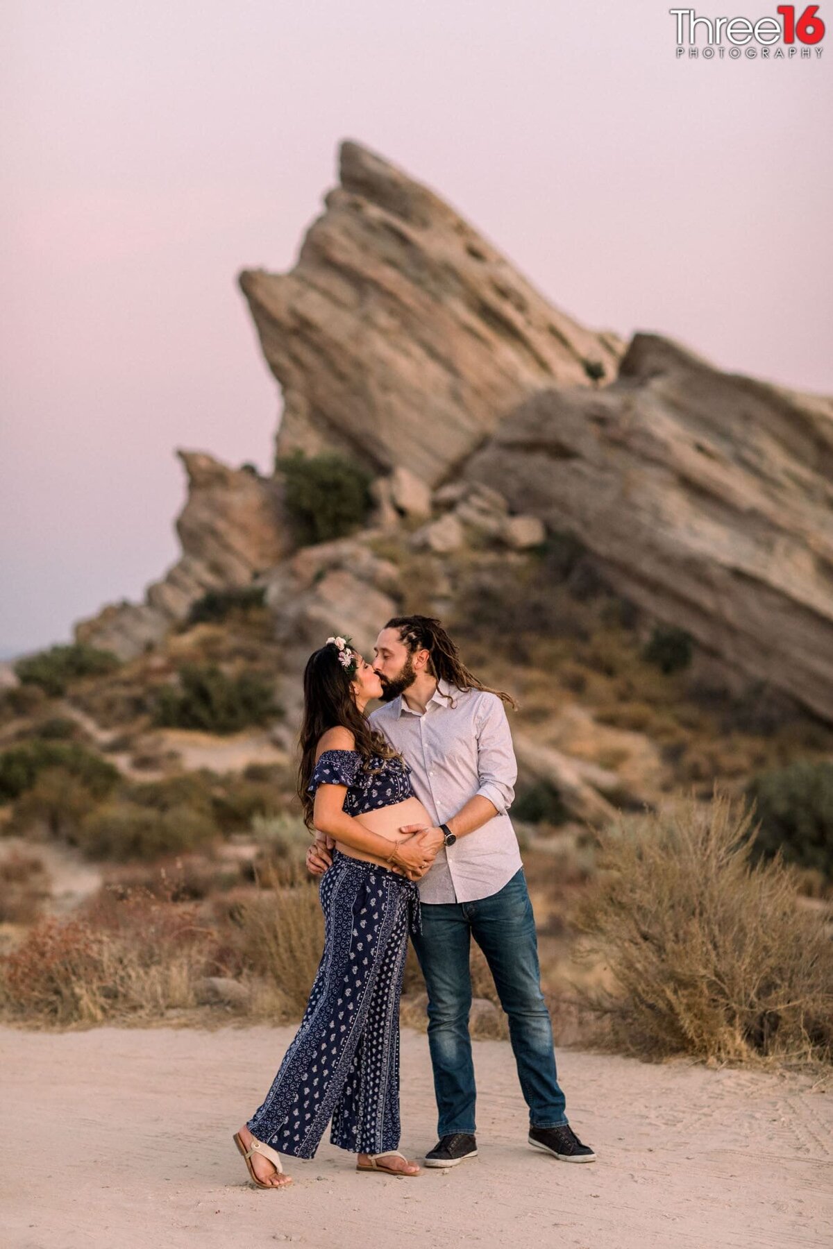 Wife receives a kiss from her husband during a Vasquez Rocks maternity session
