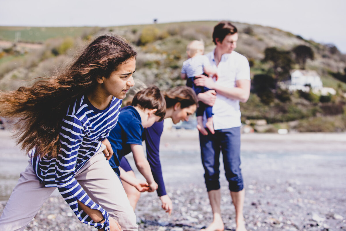 A family playing by the sea captured by Devon Wedding Photographer Liberty Pearl Photography