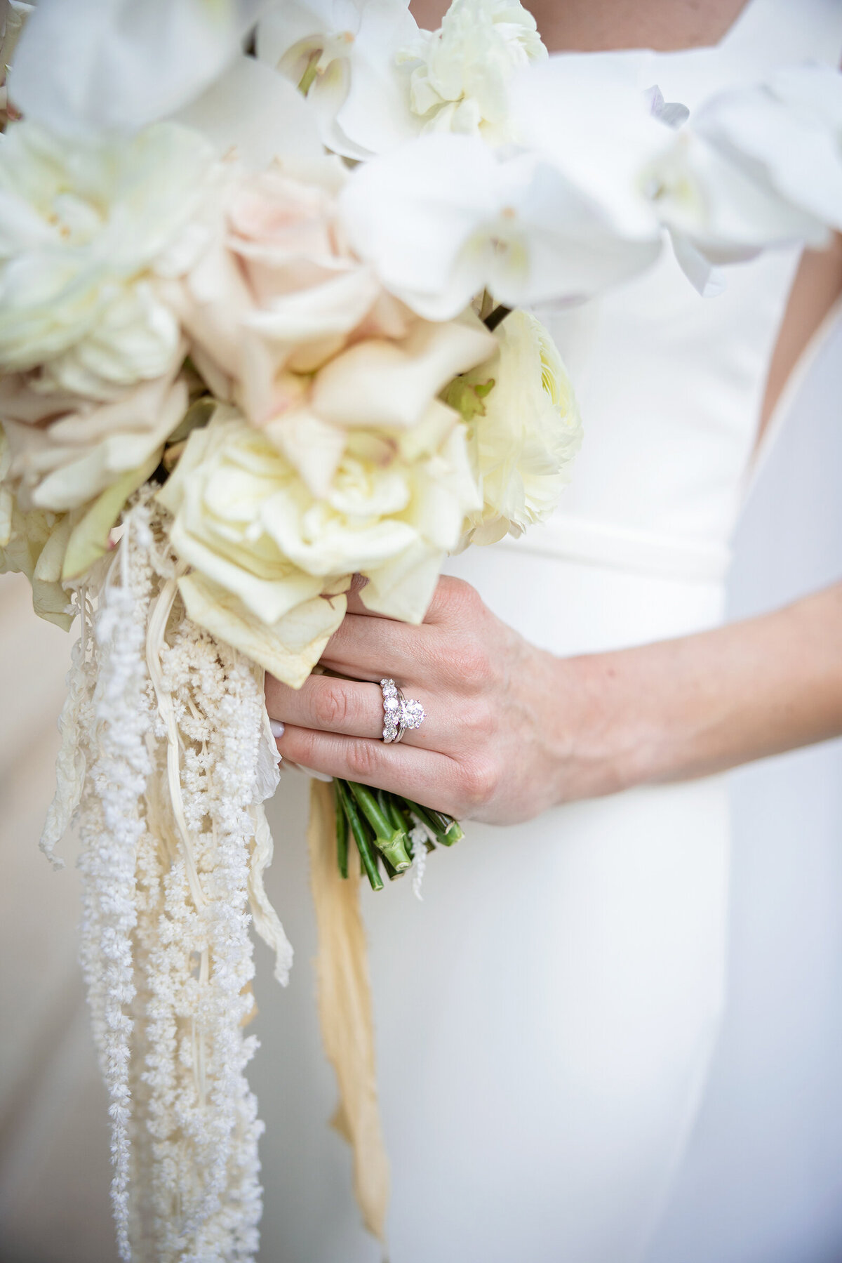 A picture of bride holding white orchid wedding bouquet